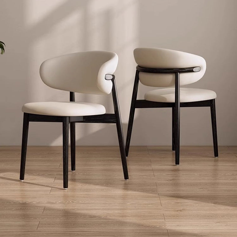 Two KROSNT chairs placed back-to-back in a sunlit, modern dining room setting with hardwood floors.