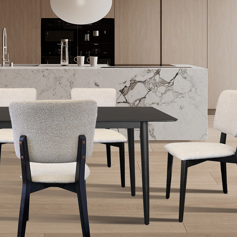BASK chair (off-white fabric, black wood legs) positioned against a dark wood table and a light marble kitchen island.