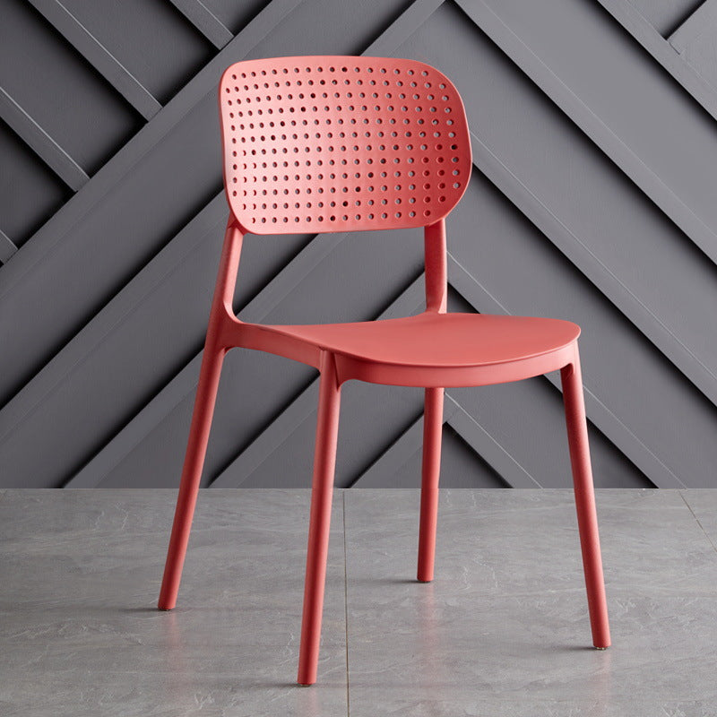 Single NOKE dining chair in red with perforated, breathable backrest and durable polypropylene construction.