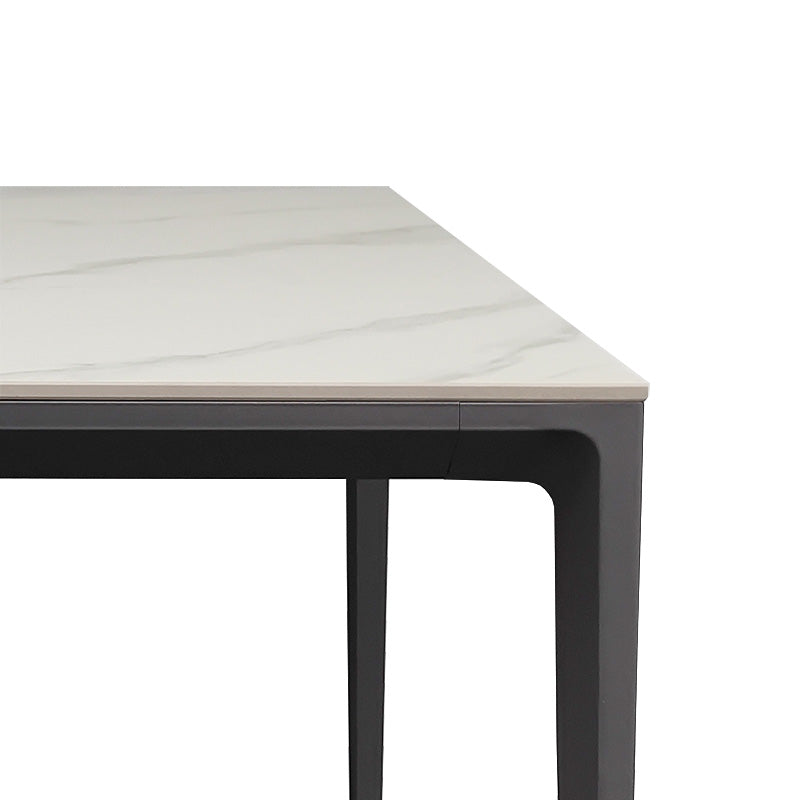 Close-up detail of the RAG Contemporary Sintered Stone Dining Table. The image focuses on a corner, showing the white sintered stone top with subtle gray marble veining resting on a dark gray aluminum alloy frame and leg.
