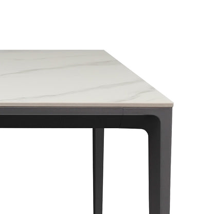 Close-up detail of the RAG Contemporary Sintered Stone Dining Table. The image focuses on a corner, showing the white sintered stone top with subtle gray marble veining resting on a dark gray aluminum alloy frame and leg.