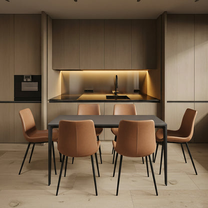 RAG Contemporary Dining Table with a black top and matching black aluminum legs, positioned in a contemporary kitchen with wood veneer cabinets. The table is set with six tan leather dining chairs.
