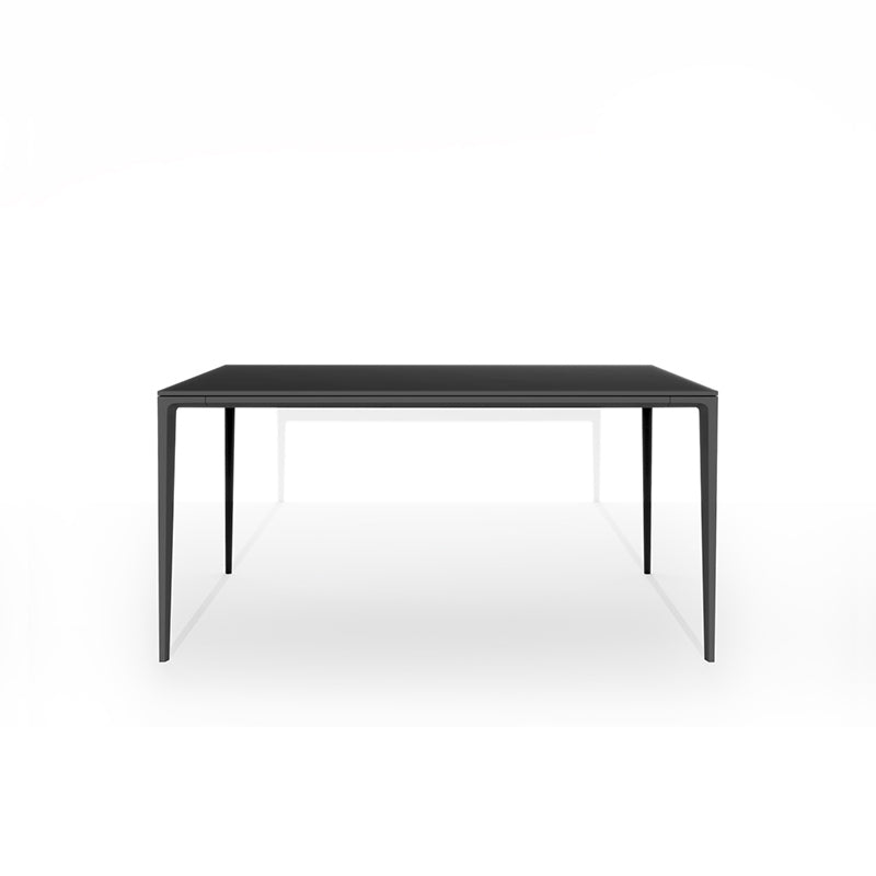 Front perspective studio shot of the RAG Contemporary Sintered Stone Dining Table. The table has a black top and black aluminum legs, isolated on a white background. Dimensions: 140CM x 80CM (55in x 31.5in).