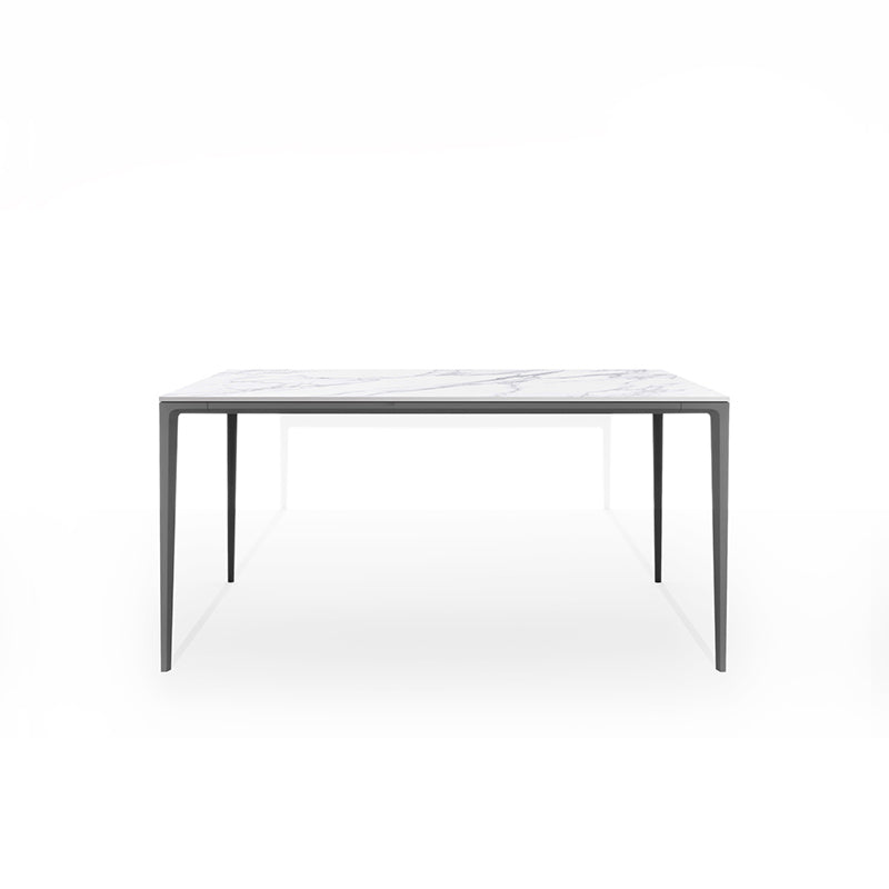 Front perspective studio shot of the RAG Contemporary Sintered Stone Dining Table. The table has a white marble pattern top and grey aluminum legs, isolated on a white background. Dimensions: 140CM x 80CM (55in x 31.5in).