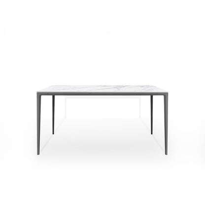 Front perspective studio shot of the RAG Contemporary Sintered Stone Dining Table. The table has a white marble pattern top and grey aluminum legs, isolated on a white background. Dimensions: 140CM x 80CM (55in x 31.5in).