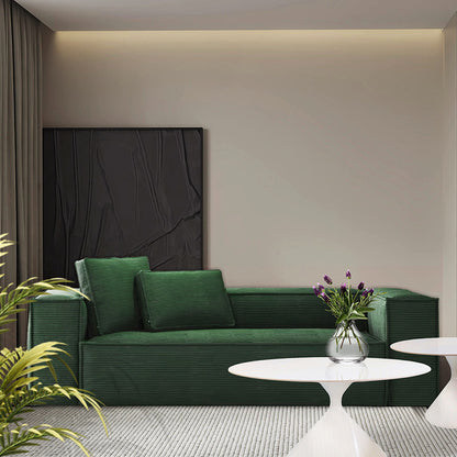 Modern living room featuring CUBE green corduroy sofa with deep seating, minimalist coffee tables, and contemporary wall art.