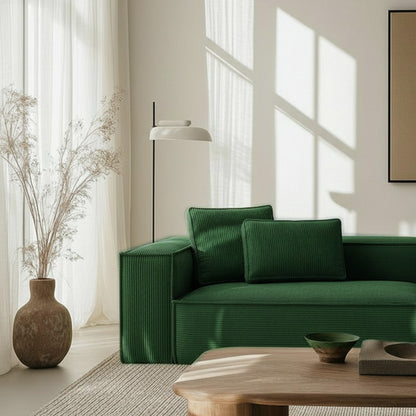Close-up of CUBE frameless sofa in forest green fabric in a bright, sunlit room with minimalist decor and natural textures.