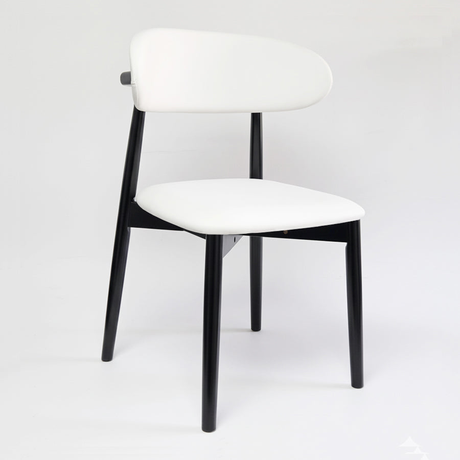 KROSNT sculptural chair side view, showing tapered black legs and curved white upholstered seat.