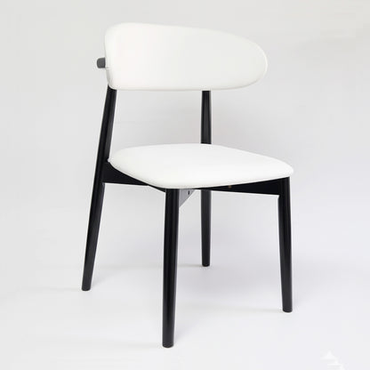 KROSNT sculptural chair side view, showing tapered black legs and curved white upholstered seat.