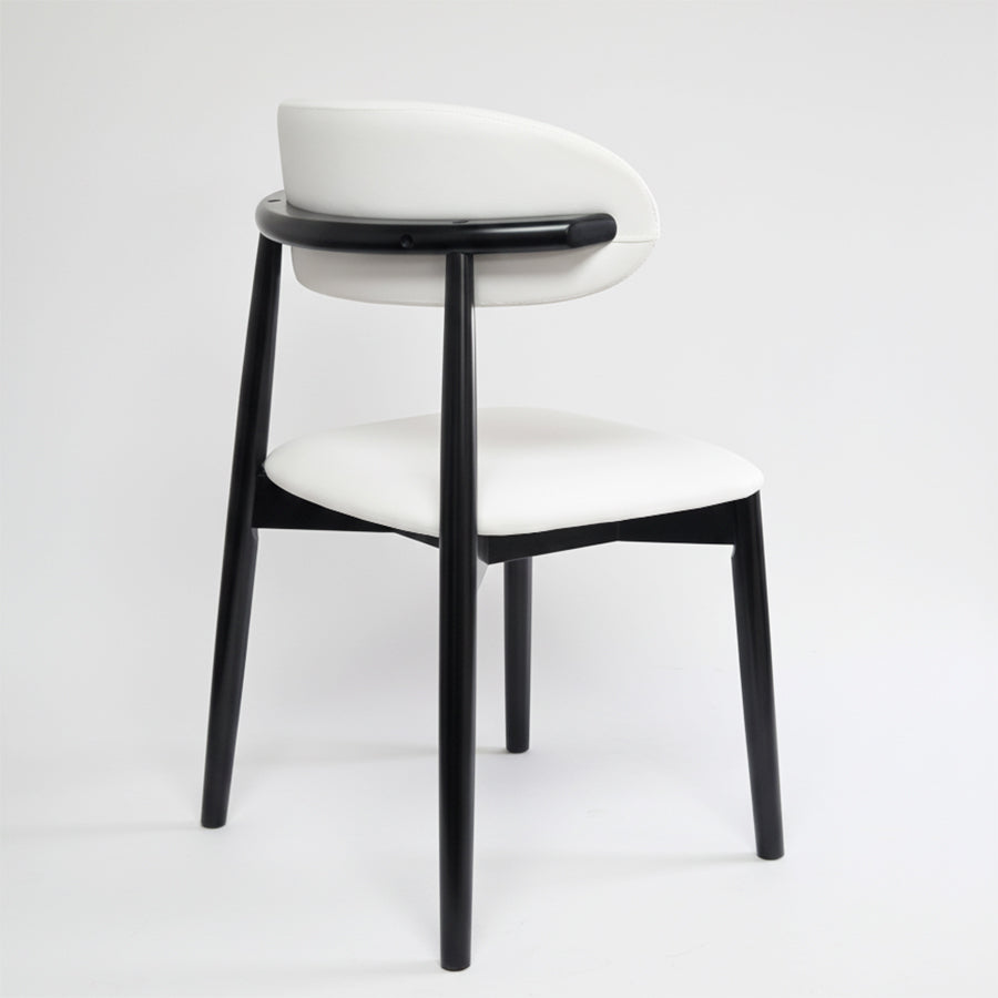 Back view of the KROSNT dining chair highlighting the unique rounded black wood frame and smooth white upholstery.