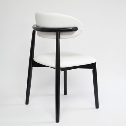 Back view of the KROSNT dining chair highlighting the unique rounded black wood frame and smooth white upholstery.