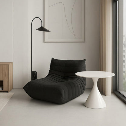 Black Togo-style fabric lounge chair showcasing a deep-seated, comfortable frameless structure in a bright contemporary space.