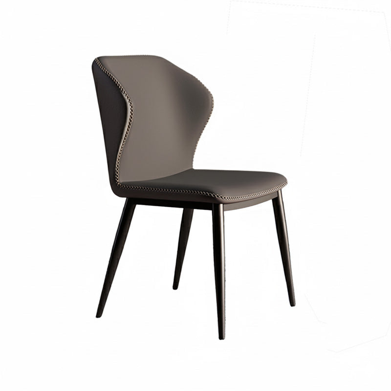 45-degree angle view of the modern BF dining chair, upholstered entirely in uniform dark grey faux leather with prominent contrast stitching details, supported by black tapered metal legs.