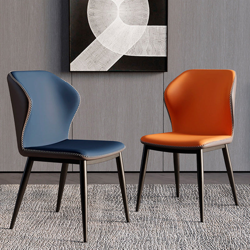 Front view of two BF two-tone dining chairs, featuring dark blue and vibrant orange faux leather options with contrast stitching and black metal legs.