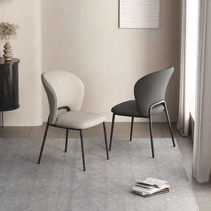 Lifestyle setting with two GIMOTI dining chairs, one light beige and one dark grey, showcasing the modern design and slim metal legs on a grey rug.