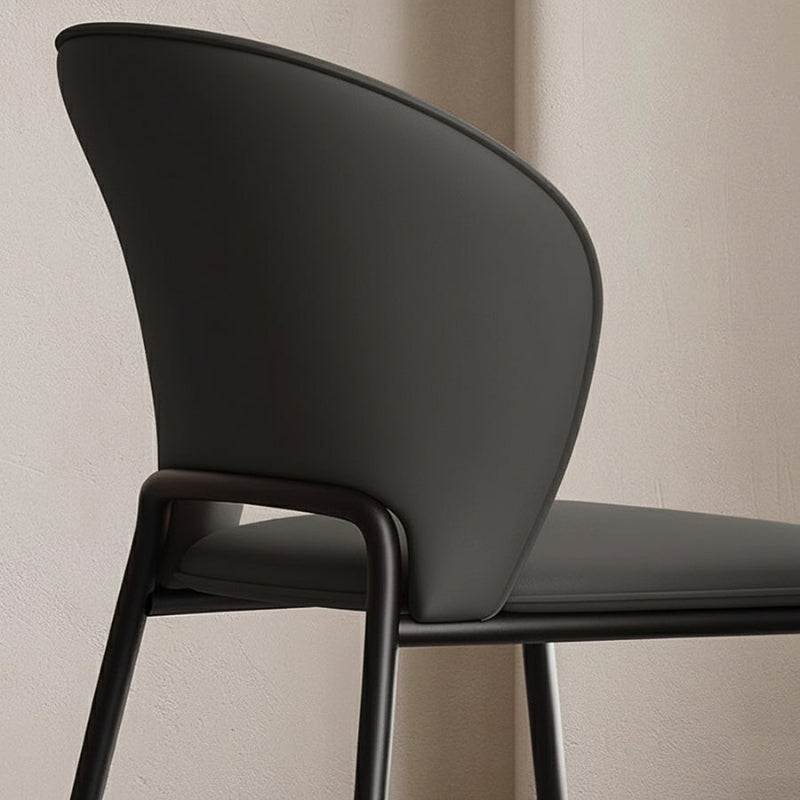 Close-up detail of the GIMOTI chair's dark grey faux leather backrest, focusing on the smooth texture and the connection to the curved metal frame.