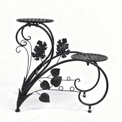 FLORON Black Wrought Iron Two-Tier Flower Stand, featuring intricate vine, leaf, and scrollwork design. Includes two circular mesh planter platforms, front view on a white background.