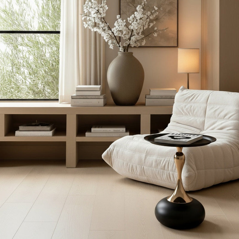 Black and gold Golp side table styled in front of a white modern Togo sofa