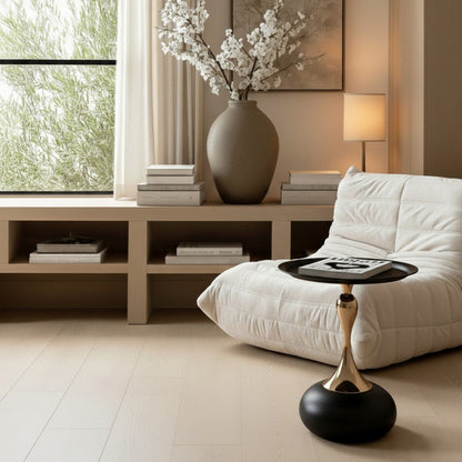 Black and gold Golp side table styled in front of a white modern Togo sofa