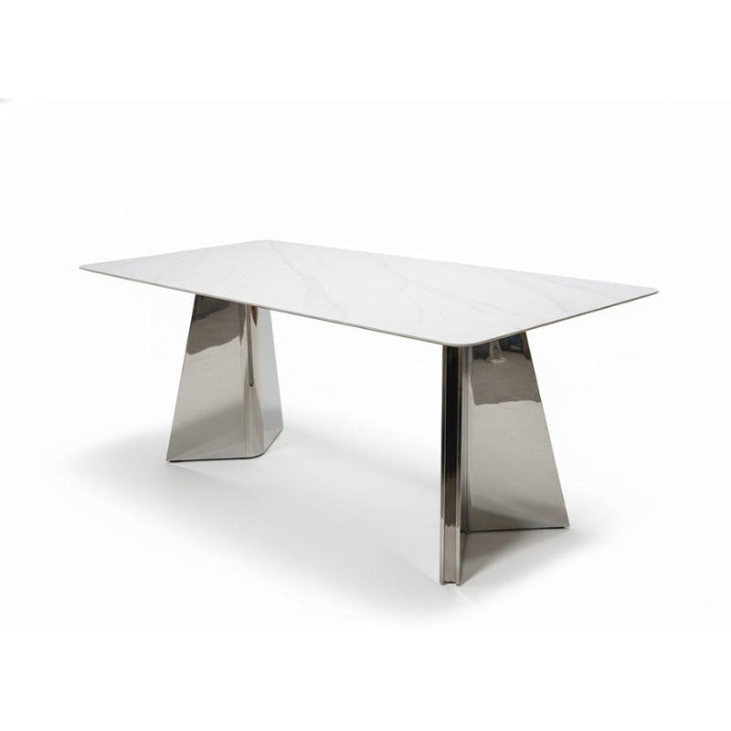 ARYLLIS dining table shown in a 45-degree angled view, featuring a marble-pattern sintered stone top and mirror-finish stainless steel base.