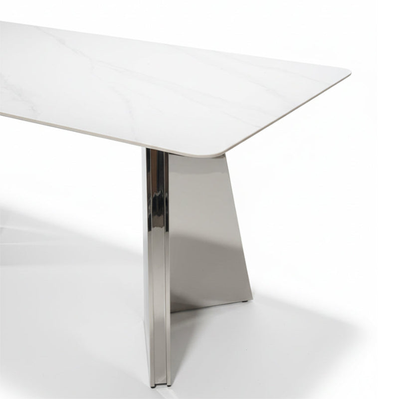 Close-up detail view of the ARYLLIS dining table’s mirror-finish stainless steel base and marble-pattern sintered stone surface.