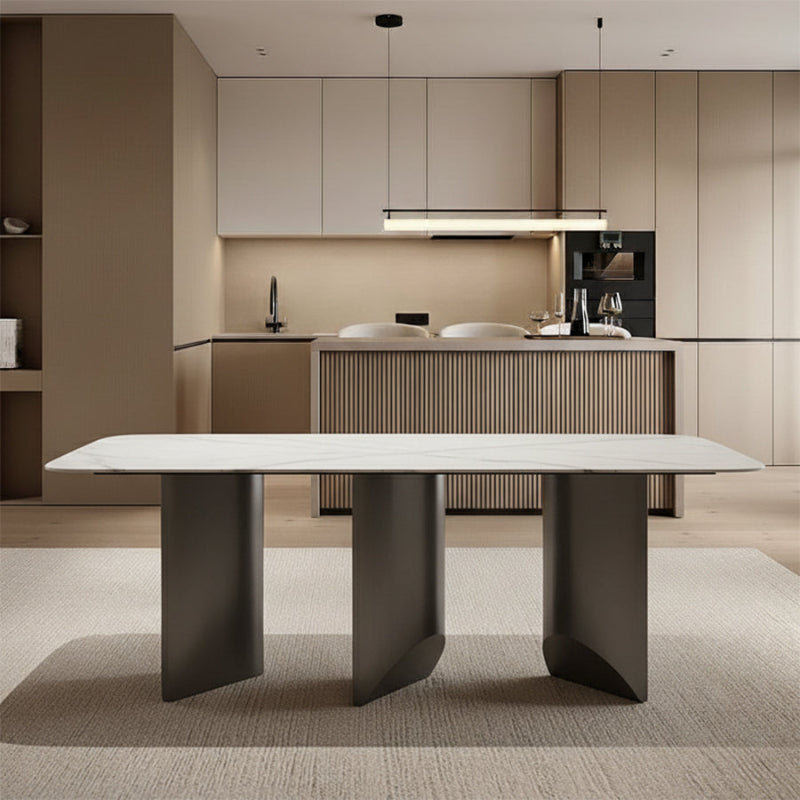 Open-concept dining area scene: BVEL Sintered Stone table placed in front of a modern kitchen island/bar, featuring light wood floors and area rug.