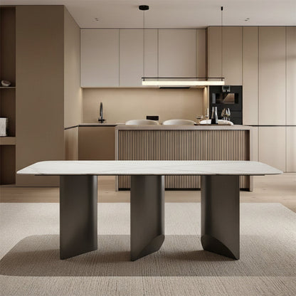 Open-concept dining area scene: BVEL Sintered Stone table placed in front of a modern kitchen island/bar, featuring light wood floors and area rug.