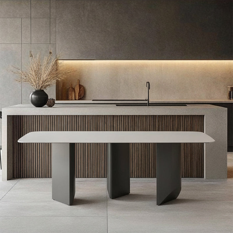 Open-concept dining area scene: BVEL Sintered Stone table placed in front of a modern kitchen island/bar.