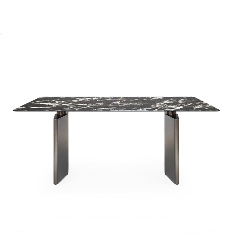 Front perspective view of the 180cm /71in DIMON dining table, featuring a dramatic black Sintered Stone top with white veining, set on two matte gunmetal steel angular bases against a pure white background.