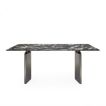Front perspective view of the 180cm /71in DIMON dining table, featuring a dramatic black Sintered Stone top with white veining, set on two matte gunmetal steel angular bases against a pure white background.
