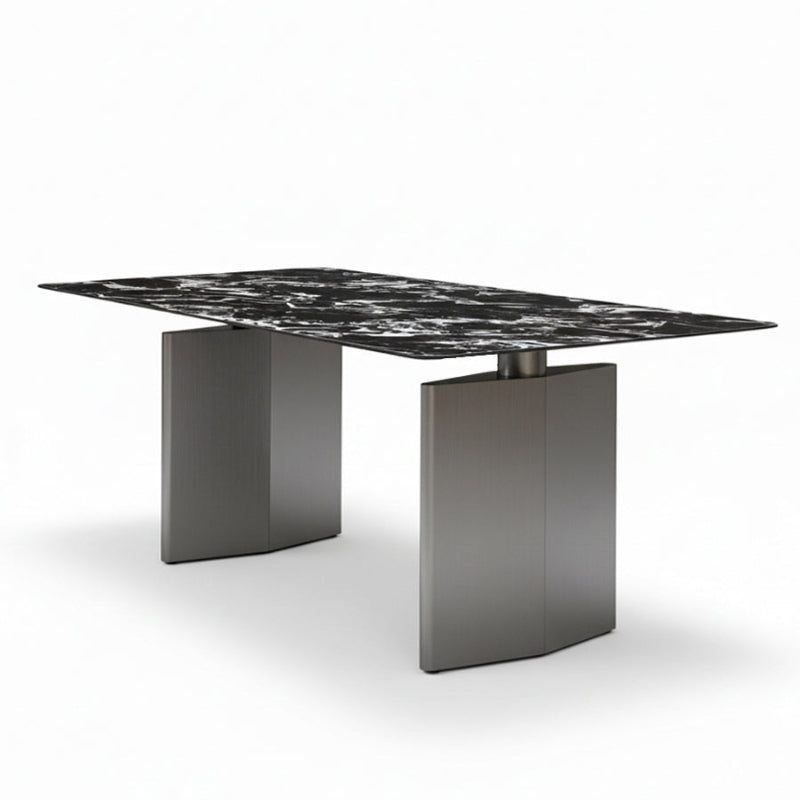 Angled view of the DIMON dining table on a white background, showcasing the rich black Sintered Stone surface and the bold, architectural lines of the two grey steel pedestal legs.