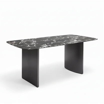 Angled perspective of the OLIV dining table showing its rounded edges, sintered stone surface, and modern stainless steel base.