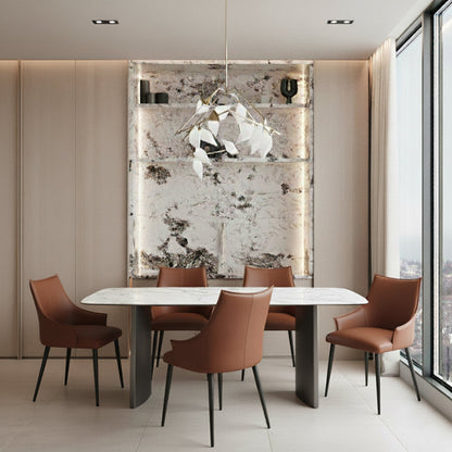 OLIV dining table placed beneath a contemporary chandelier in a dining room setting, highlighting the glossy sintered stone tabletop and minimalist design.
