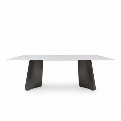 Front perspective view of the PETLS Sintered Stone dining table, featuring a white marble-look top and two wide, angled gunmetal grey steel pedestal bases, isolated on a clean white background.