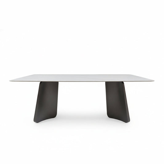 Front perspective view of the PETLS Sintered Stone dining table, featuring a white marble-look top and two wide, angled gunmetal grey steel pedestal bases, isolated on a clean white background.