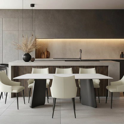 Lifestyle scene: The PETLS Sintered Stone dining table paired with 6 white faux leather dining chairs, positioned elegantly in front of a modern kitchen island and cabinetry.
