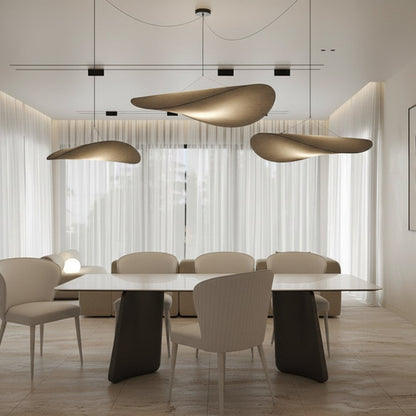 Dining room scene: The PETLS table with a white Sintered Stone top and white faux leather chairs, illuminated by a contemporary chandelier, creating a sophisticated living-dining space.
