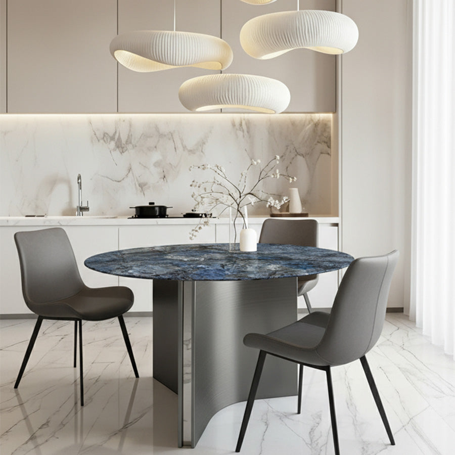 Lumara 47-inch round sintered stone dining table with blue marble top and gray stainless steel legs, styled with SADE upholstered dining chairs