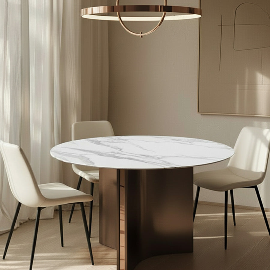 Lumara 47-inch round sintered stone dining table with white marble top and bronze stainless steel legs, styled with SADE upholstered dining chairs