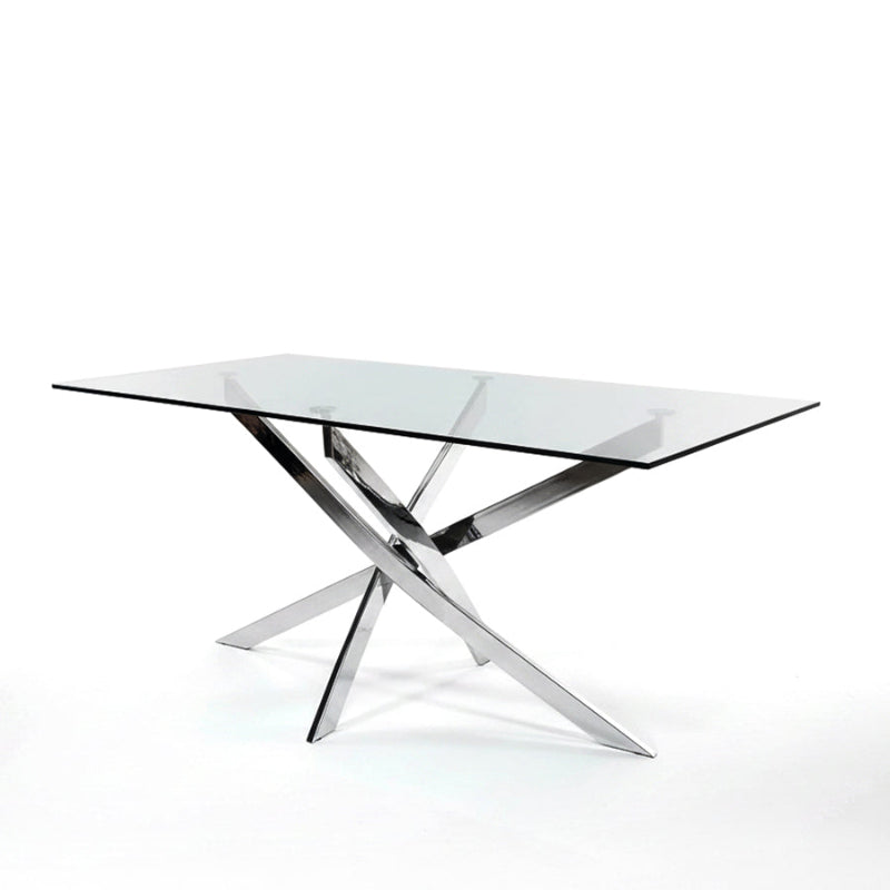 45-degree angled view of the VERDIS glass dining table featuring a clear tempered glass top and mirror-finish stainless-steel legs