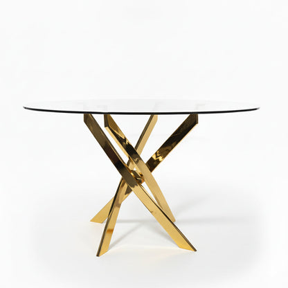 45-degree view of the VERDIS round dining table with tempered glass top and polished gold stainless-steel cross base
