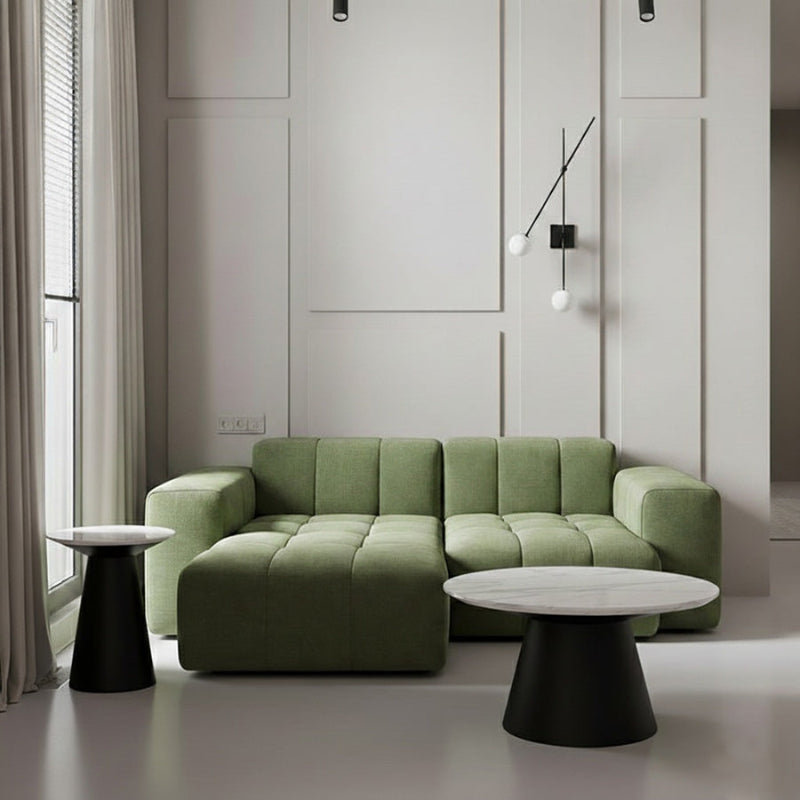 Bentrio coffee table set with matte black stainless steel bases, positioned in front of a green BUCKLOE sofa, enhancing a modern and cozy living room space