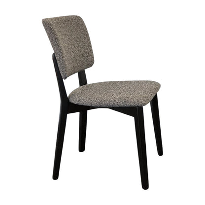BASK modern dining chair side view with solid black wood legs and grey fabric upholstery.