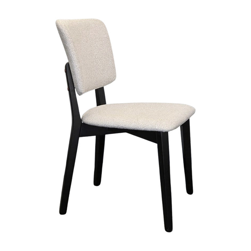 BASK modern dining chair side view with solid black wood legs and soft off-white fabric upholstery.