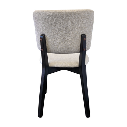 BASK modern dining chair back view with solid black wood legs and soft off-white fabric upholstery.