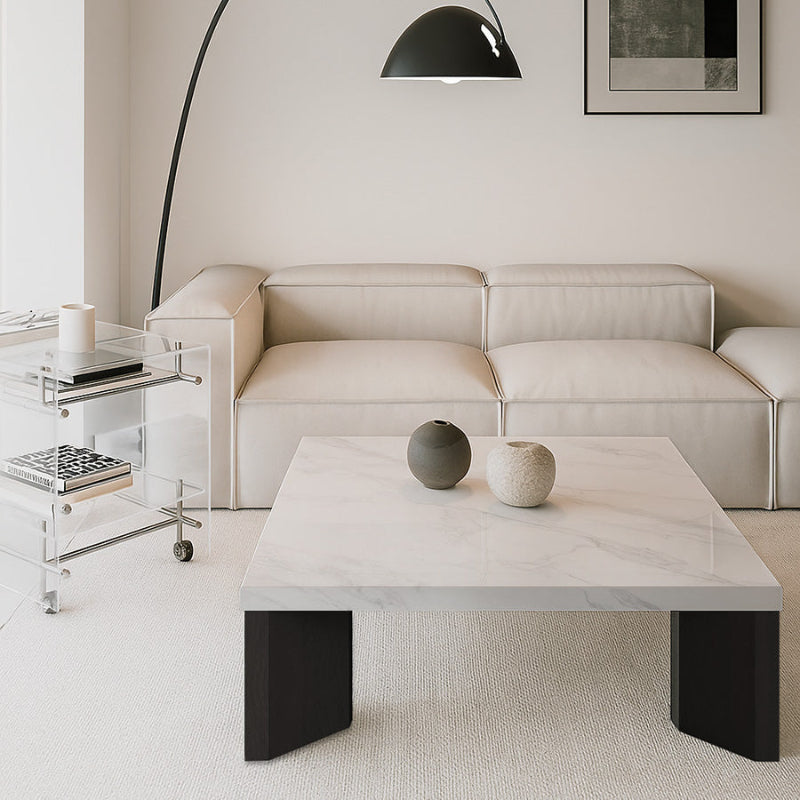 Syley square coffee table with Bulgari black top and black oak legs, positioned in front of a white sofa in an elegant, white-themed living room